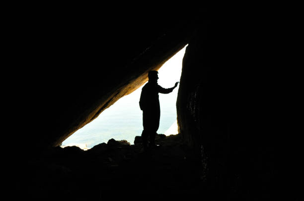 istock A biologist in field work, scientist, silhouette of man inside cave, reverse light, background 1181810854