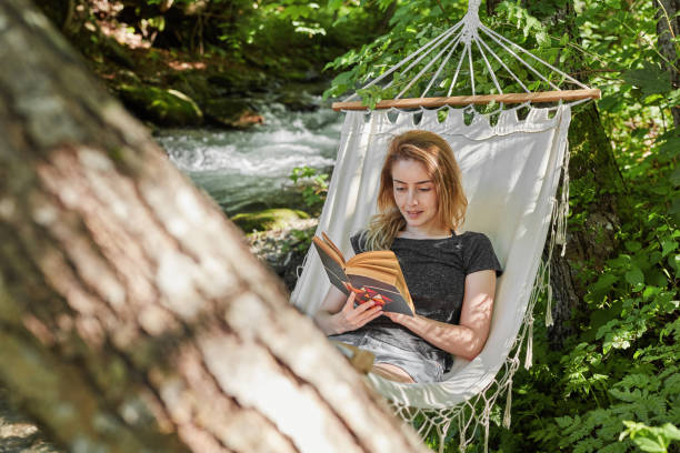 Woman reading book in hammock