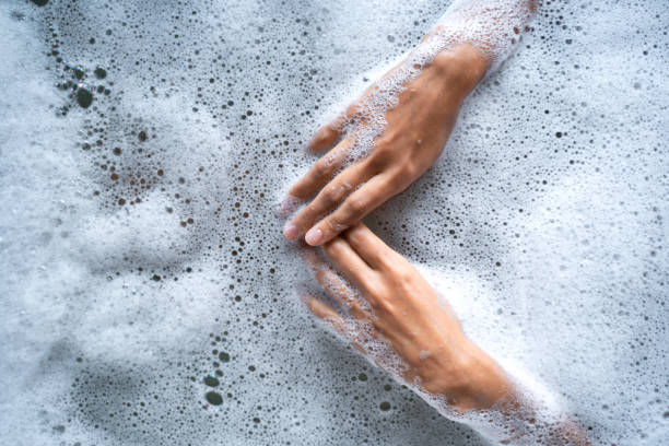 istock Female hands touching the water in a bath 1181813439