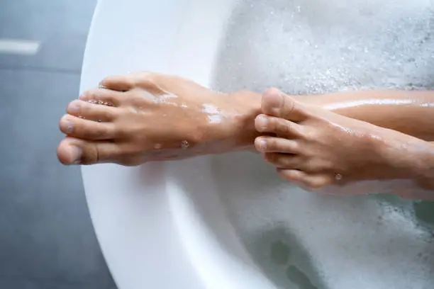 Photo of Caucasian female feet protruding from a bath