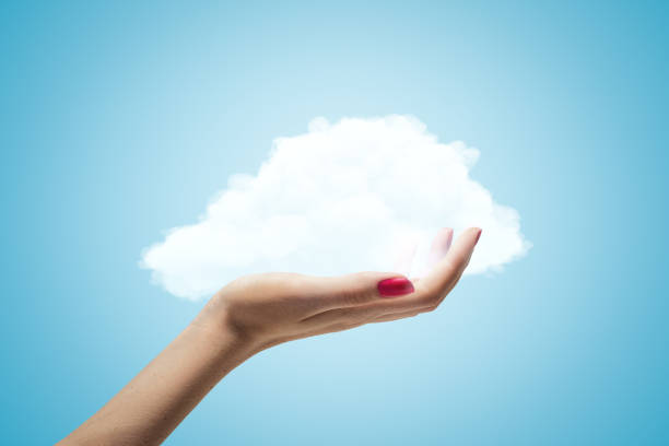 istock Female hand holding white cloud on blue background 1181814946