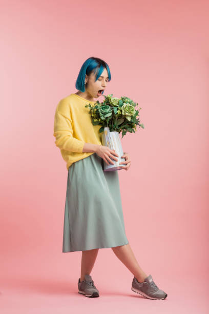 beautiful girl smelling flowers while posing to the camera