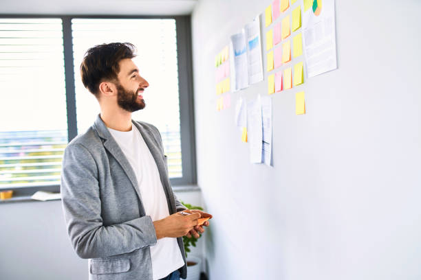 istock Happy young startup businessman looking at notes on office wall 1181817949