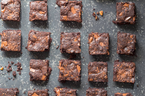 istock Chocolate brownie cake squares on black mottled texture background - top view angle 1181820912