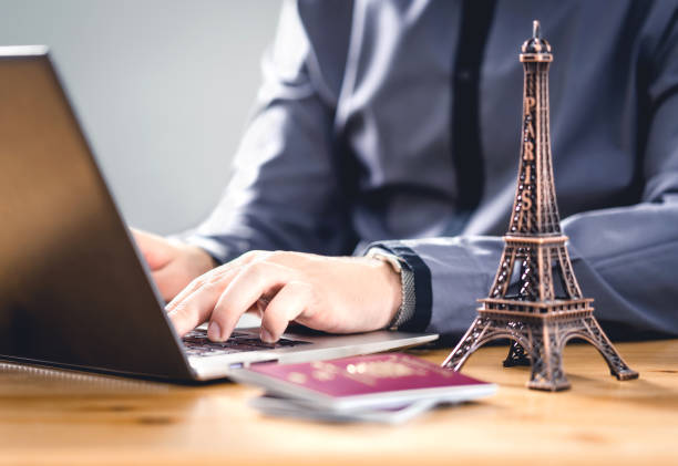 istock Passport for vacation. Travel document for online reservation or electronic visa identification. Tourism in EU. Tourist booking a holiday in France with laptop. 1181822125