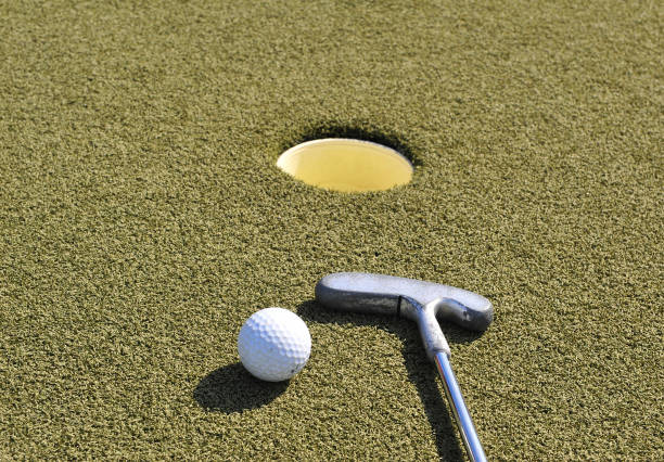 istock Mini golf stick and ball at the hole on grass 1181823526