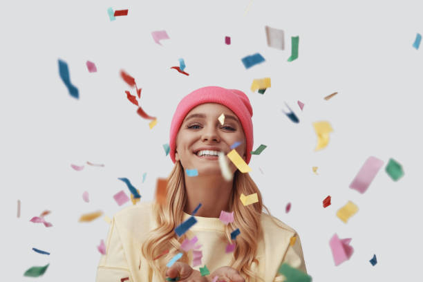 istock Attractive young woman looking at camera and smiling while standing against grey background 1181824199