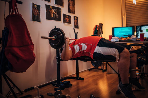 自宅で体重を持つ男のトレーニング - weight bench ストックフォトと画像