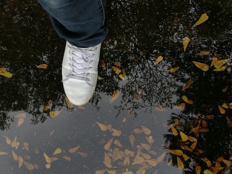 Top view angle of stepping into a rain puddle.