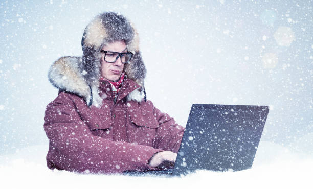 homem congelado na roupa vermelha do inverno que trabalha em um portátil na neve. frio, geada, nevasca - computer programmer laptop men nerd - fotografias e filmes do acervo