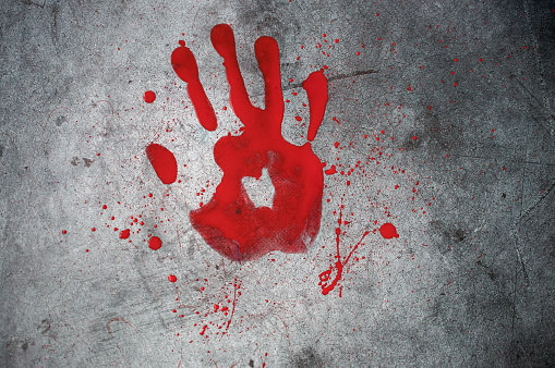 Red bloody footprint of a hand with bloody spray on a black background. Horror, mysticism, background for halloween