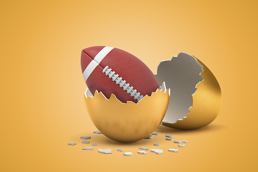 3d rendering of american football ball hatching out of golden egg on yellow background. Games and sports. Outdoor activities. Sporting goods.