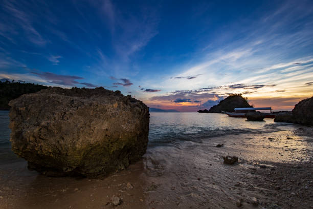 da vicino su una roccia al tramonto su una spiaggia vicino al giardino di corallo sull'isola di san antonio, puerto galera, regione orientale di mindoro nelle filippine. - puerto galera foto e immagini stock