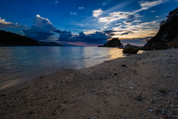 tramonto su una spiaggia vicino al giardino di corallo sull'isola di san antonio, puerto galera, regione orientale di mindoro nelle filippine. - puerto galera foto e immagini stock