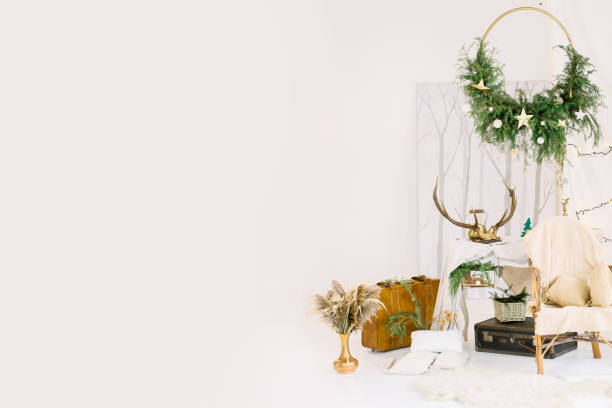 istock Christmas decorations, wicker chair with white plaid, leather suitcases, in white hall in studio 1181837770