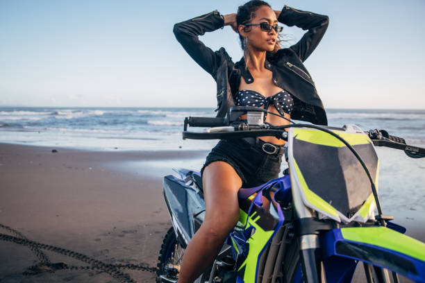 istock Woman sitting on motorcycle on the beach 1181840025