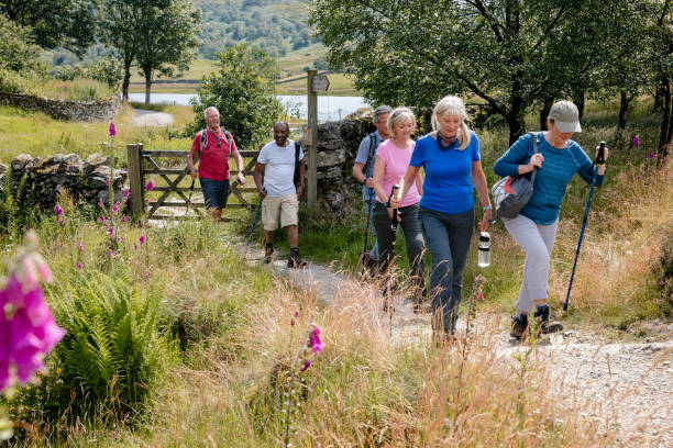 senior friends out walking in the lakes - walking exercising relaxation exercise group of people imagens e fotografias de stock