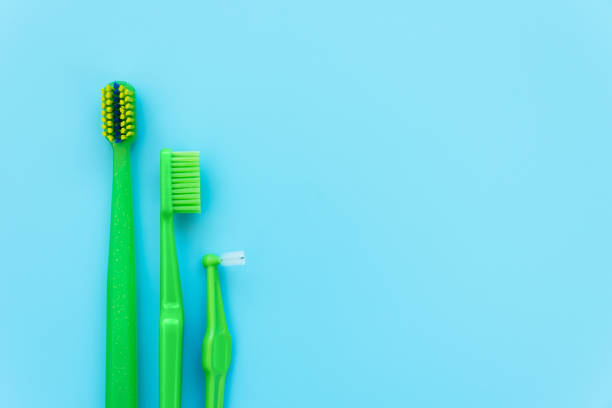 brosses à dents interdentaires originales, orthodontiques et à angle sur fond bleu. sain. flat lay. vue du haut - toothbrush plastic multi colored hygiene photos et images de collection