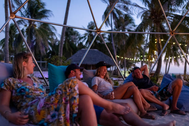istock Friends enjoying a sunset next to a bonfire on a tropical island 1181842013