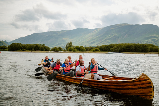 Friends cheering each other on rowing out on the open water