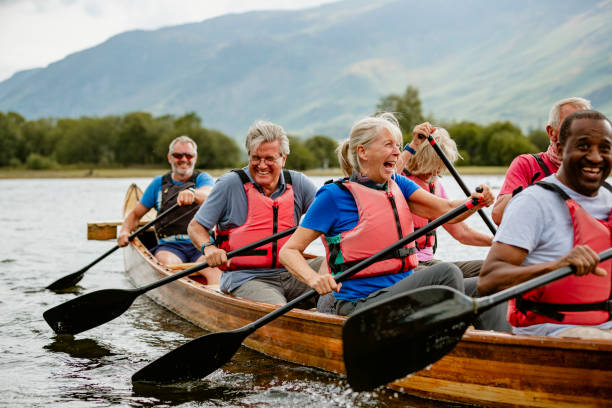 Seniors Enjoying And Having Fun In Rowing Boat A senior group of friends enjoying rowing on the River Derwent rowboat stock pictures, royalty-free photos & images