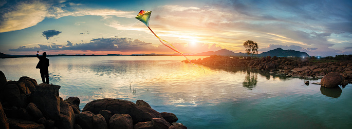 Businessman relaxing with a kite, Sunset at Gaborone dam, in Botswana after a short rainfall