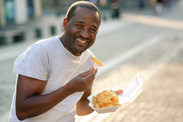 Portrait of a smiling man eating chips