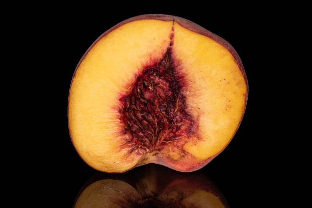 istock Sweet red peach isolated on black glass 1181848463