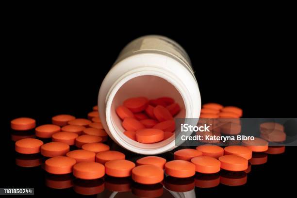 Orange Pharmacy Tablet Isolated On Black Glass Stock Photo - Download Image Now - Granule, Plastic, Stack