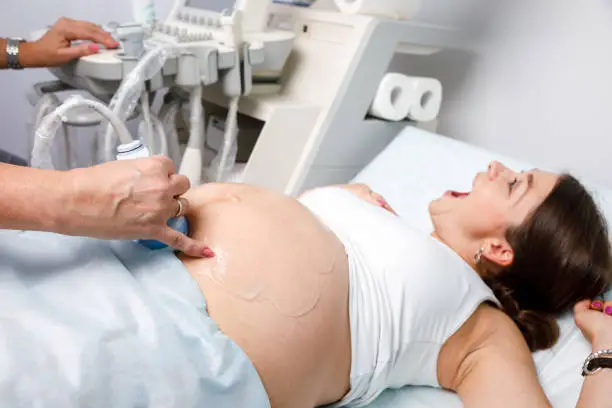 Photo of Joyful pregnant woman received good news doing obstetric ultrasonography