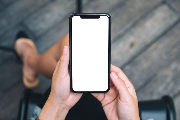 istock a woman holding a black mobile phone with blank white desktop screen 1181857768
