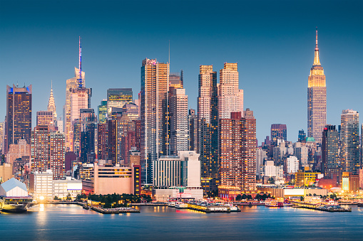 New York, New York, USA Midtown Manhattan skyline on the Hudson River at night.