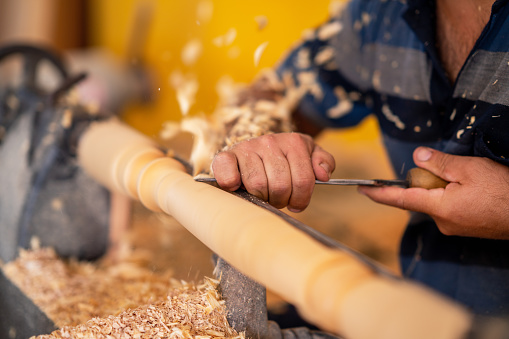 Carpenter working on wood to carving and shaping.