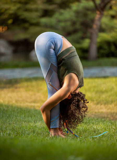 Yogi woman make uttanasana pose in nature