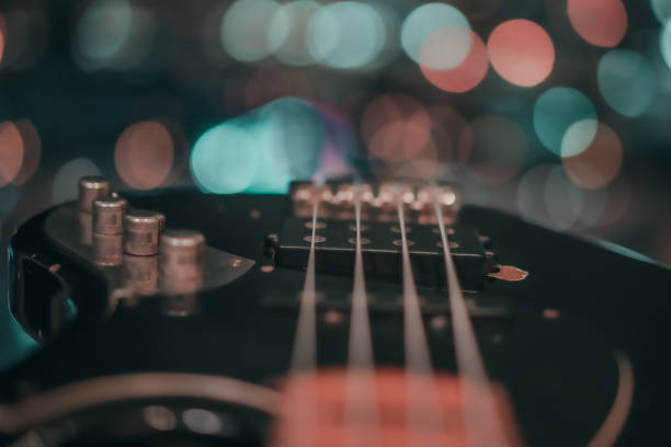 Electric bass guitar blurred background Electric bass guitar blurred background with beautiful bokeh. bass guitar stock pictures, royalty-free photos & images