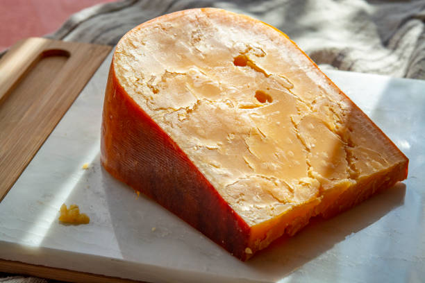 istock Three years old dark yellow hard Dutch cheese in sun lights 1181860813