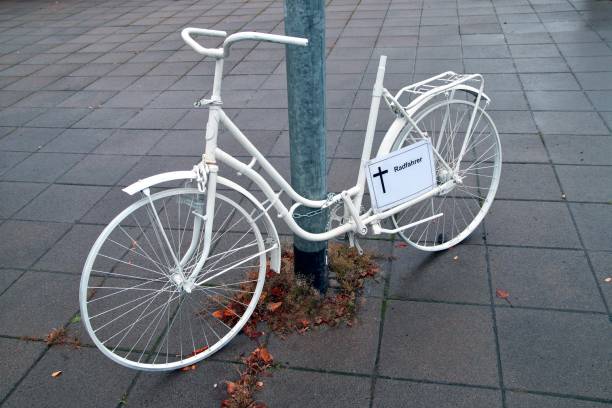 un monumento fantasma en bicicleta con un signo alemán - radfahrer - y un cruce para un ciclista asesinado en las calles de frankfurt main, alemania en un día lluvioso de dreary. memorial a un ciclista que murió en accidente de tráfico - memorial roadside cross cross shape fotografías e imágenes de stock