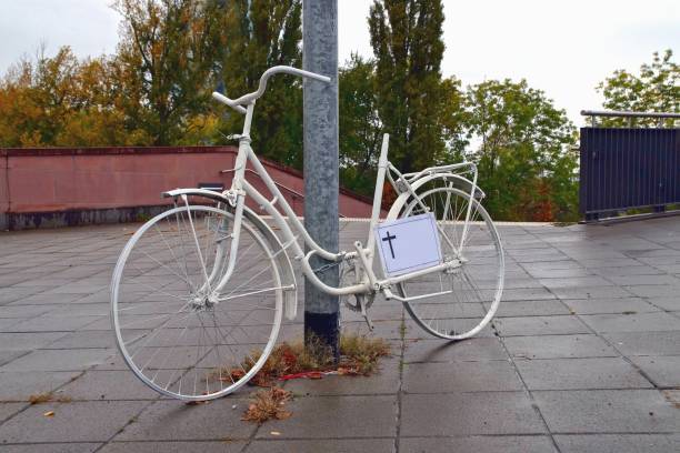 un monumento fantasma en bicicleta con un signo de cruz para un ciclista asesinado en las calles de frankfurt main, alemania, en un día lluvioso de dreary. bicicleta fantasma blanca, monumento a un ciclista que murió en accidente de tráfico - memorial roadside cross cross shape fotografías e imágenes de stock