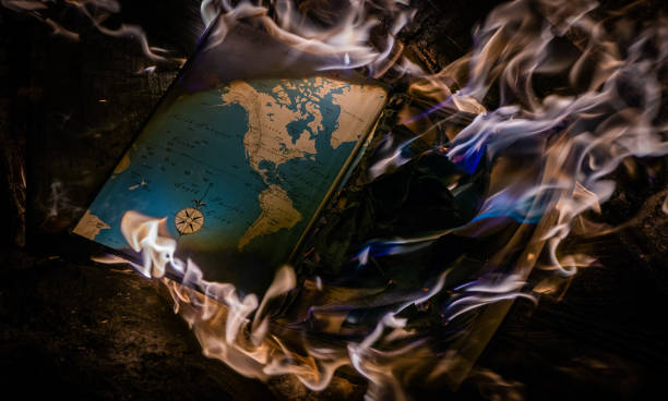 Burning Book A book with a map on the inside set a flame with blue and orange fire. book burning stock pictures, royalty-free photos & images