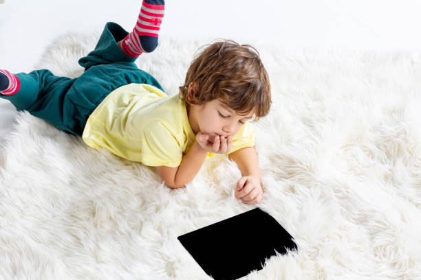 istock Little Boy working tablet on carpet 1181863964