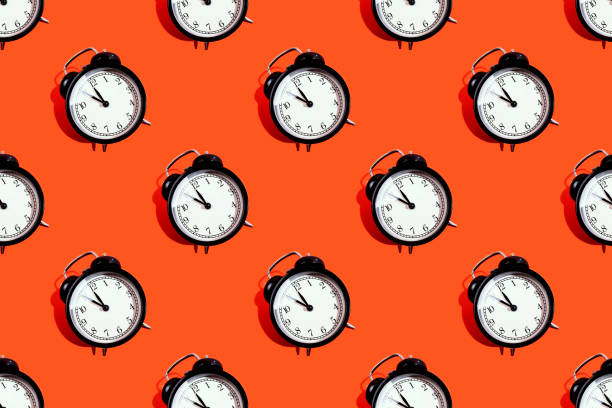 istock Many black classic style alarm clock isolated on yellow background 1181867281