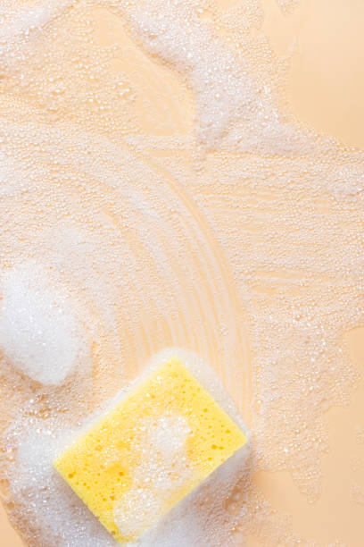 istock Yellow sponge for cleaning in foam on a soft beige background 1181867726