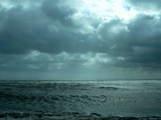 istock Sunlight breaking through clouds over the ocean on a stormy overcast day 1181868779