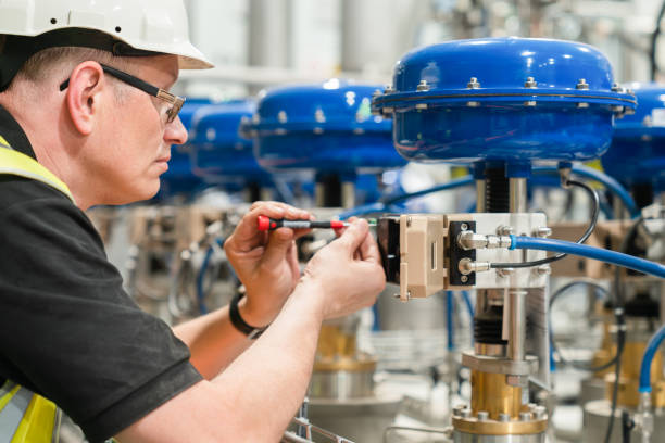 ingenieur prüft pneumatisches ventil mit einem schraubendreher - conrtol valve stock-fotos und bilder