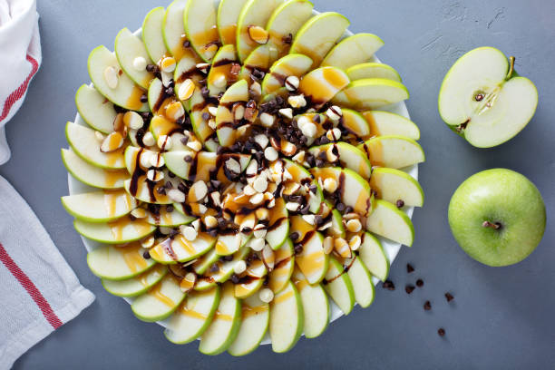 White and dark chocolate chip apple nachos Apple nachos with white and dark chocolate chips, caramel syrup and almonds nacho chip photos stock pictures, royalty-free photos & images