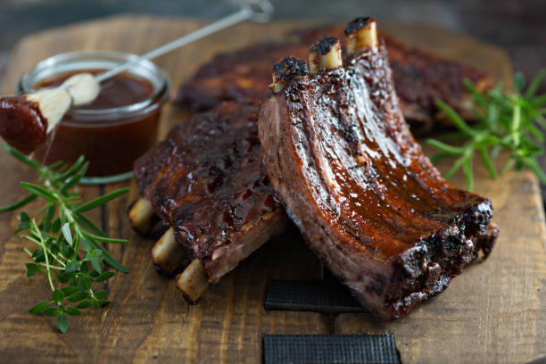 Grilled bbq ribs with sauce Grilled bbq ribs with barbeque sauce on a board smoked pork stock pictures, royalty-free photos & images