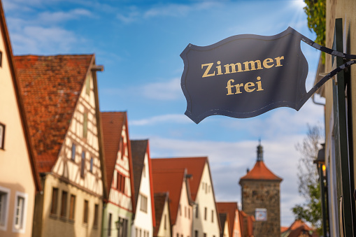 Zimmer frei (Rooms available) sign at a guesthouse or hotel with Half-timbered houses in background. Accommodation during travel by Romantic Road touristic route in Bavaria, Germany concept