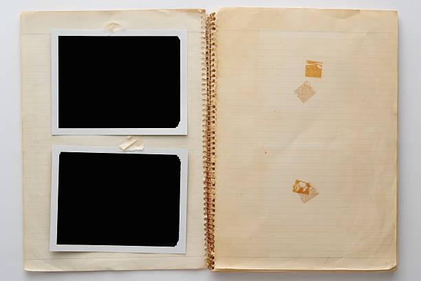 Overhead shot of old spiral notebook with two blank polaroid isolated on white background.