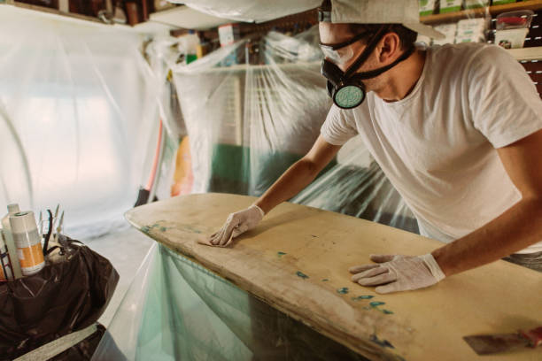 istock Young man repairing a surfboard 1181877551