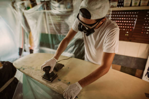 istock Young man repairing a surfboard 1181877553